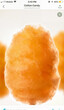 © 현욱 김 - Close-up view of fluffy orange cotton candy on a stick, displayed on a mobile phone screen with a clean white background.