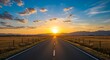 © Mowshum - Asphalt road stretching into the distance with fence on both sides under sunset sky with clouds and mountains in the background