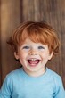 © Helen-HD - A young boy shows a big smile with his red hair shining. He stands in front of a clean background, enjoying a happy moment in his day