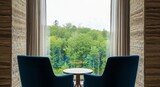 Armchairs facing window with forest view