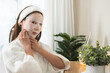 © KMPZZZ - Skin care beauty person concept. Asian young woman applying white cosmetic face mask, sheet pad for treatment moisturizing, relax spa and skin cosmetology. Lifestyle routine therapy of dermatology.