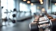 © Akash - Close-up of gym dumbbells on a rack in a bright, modern fitness studio
