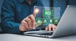 © MarufIslam - Businessman analyzing return on investment roi on a laptop with virtual interface