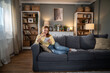 © Migma_Agency - Woman relaxing at home, using a tablet on sofa