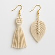 © Елена Шинкар - Original milky-colored macrame earrings: one in the shape of a braided feather, the other a decorative tassel. Gold-tone hardware, high-quality macro photography, commercial style.