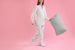 © New Africa - Beautiful woman in stylish pajamas with pillow on pink background, closeup