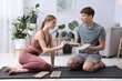 © New Africa - Young man and woman with sadhu boards on yoga mat at home