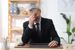© New Africa - Work fatigue. Overwhelmed businessman in suit suffering at table in office