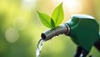 © Viktor - Green fuel pump nozzle dispenses clear liquid with fresh leaves on top. Water drops on nozzle suggest purity and eco friendly nature. Background shows soft green bokeh.