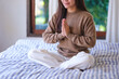 © Farknot Architect - Closeup image of a woman put hands together in a prayer and meditating on the bed at home
