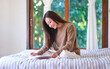 © Farknot Architect - Portrait image of a woman reading a book on the bed at home
