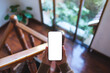© Farknot Architect - Top view mockup image of a woman holding mobile phone with blank desktop screen at home