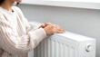 © anilkumar - close up shot of  Woman warming her hands near radiator indoors,