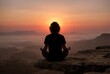 © Meow Creations - Silhouette of a person meditating in a lotus pose on a mountain cliff at sunset