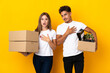 © luismolinero - Teenager couple moving in new home among boxes isolated on blue background surprised and shocked while looking right