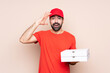 © luismolinero - Young man holding a pizza over isolated background has just realized something and has intending the solution
