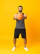 © luismolinero - Full-length shot of man over isolated yellow background playing basketball
