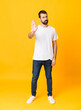 © luismolinero - Full-length shot of man with beard over isolated yellow background making stop gesture