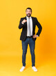 © luismolinero - Full-length shot of business man over isolated yellow background surprised and pointing front