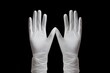 © juliars - White medical gloves creating a w shape with fingers spread open, isolated against a black backdrop