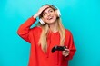 © luismolinero - Young Uruguayan woman playing with a video game controller isolated on blue smiling a lot