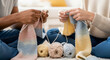 © Tamaras Pictures 4U - Two people knitting colorful socks on the floor with yarn balls