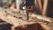 © ds17 - A close-up of a power drill with a metal bit drilling into a wooden plank. Wood shavings scatter around, indicating active woodworking.
