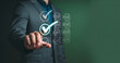 © AnupKumar - Businessman hand touching digital checklist checkmark interface for project management task completion and quality control evaluation