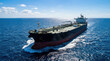 © angelmaxmixam - Large commercial tanker ship sails across deep blue ocean waters under a bright, clear sky. Global freight transportation on a sunny day.