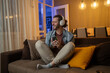 © Nenad - Chearful handsome man listening to music online at home