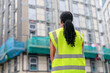 © Iryna - Woman wearing safety jacket looks at construction site