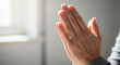 © Irina Kado - hands in prayer close up detail of folded hands in a gesture of prayer near a softly lit window. Image can be used for themes of spirituality, meditation, and Christian devotion.