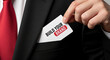 © Inspire Shots Hub - Close-up of a suit with a hand holding a card reading 'Build Your Brand', concept: business growth, marketing, success and professional identity