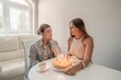 © svetograph - Birthday Cake Women Home Celebration: Two women celebrate a birthday with a cake indoors, sharing a tender moment. Happy birthday.