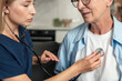 © brizmaker - Doctor checks heartbeat of elderly woman during home healthcare visit