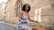 © Ree - Woman riding bicycle through historic european street in summer