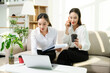 © Nuttapong punna - Two professional businesswomen working together with laptop, coffee and smartphone at home office. Remote work, startup teamwork, modern business lifestyle.