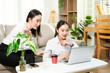 © Nuttapong punna - Two businesswomen discussing ideas while working with laptop at home office. Remote work, teamwork, collaboration, startup meeting and modern business lifestyle.