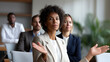 © dinatychynska - Businesswoman explaining decision to team in office meeting. Female executive delivering serious news, professional rejection or refusal. Corporate communication, difficult conversation, leadership.