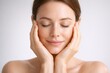 © Alamin - Beautiful woman with closed eyes touching her face for skincare wellness and relaxation day