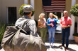 © wavebreak3 - Caucasian military soldier with bag walking towards family standing at the entrance