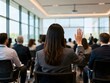 © Rashidul - Rear View Businesswoman Raising Hand in Conference Meeting, Corporate Seminar Audience Participation, Professional Workshop Event Background 8K