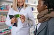 © zinkevych - Sick african american girl talking to a pharmacist in a drug store