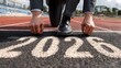 © Nail - Business Man preparing to run on athletics track engraved with the year 2026. Concept: Future planning, business growth, motivation, goal setting, new year strategy, leadership, readiness for change