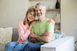 © zinkevych - Older adults sitting close smiling in cozy living room