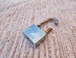 © Muhammad - ​Broken silver padlock with a rusted, cut shackle lying on a textured ground. Concept of security breach, burglary, theft, and failed safety protection