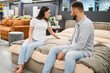 © Serhii - Young couple choosing new bed in furniture store