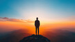 © AH TAR STOCK - A man stands on a mountain top at sunset, looking out over the horizon