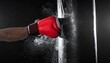 © ruangrit19 - Power Punch Red Boxing Glove Hitting Heavy Bag Force and Determination Concept Studio Shot.