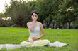 © leungchopan - Woman doing breath practice at green park